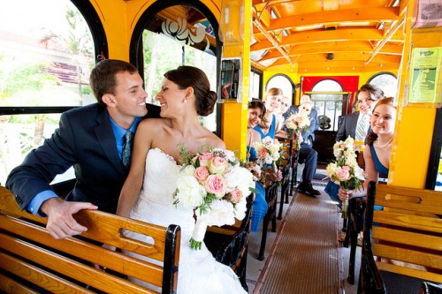 Bride and Groom inside Victorian Trolley with wood seats and full wedding party of 14 people in a 23 passenger rental leaving church heading to cescaphe ballroom Philadelphia for reception