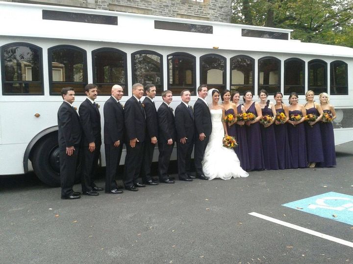 White Trolley Rental Philadelphia Wedding Party Bridemaids Grooms Men Best Man Bride Groom Red Yellow Orange Flowers outside Transportation heading to delaware from church to Cescaphe